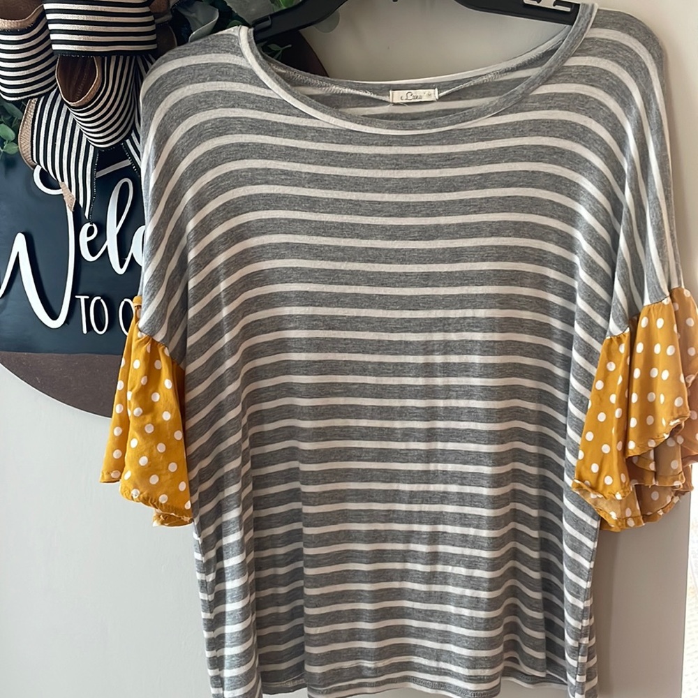 Medium gray and white stripes with yellow polkadot, ruffle sleeves.